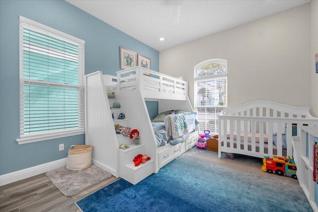 bedroom featuring carpet flooring, ceiling fan, and a nursery area