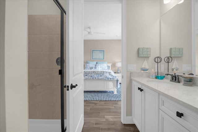 bathroom featuring ceiling fan, vanity, wood-type flooring, and an enclosed shower