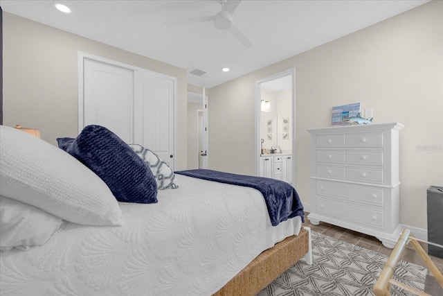 tiled bedroom featuring connected bathroom, a closet, and ceiling fan