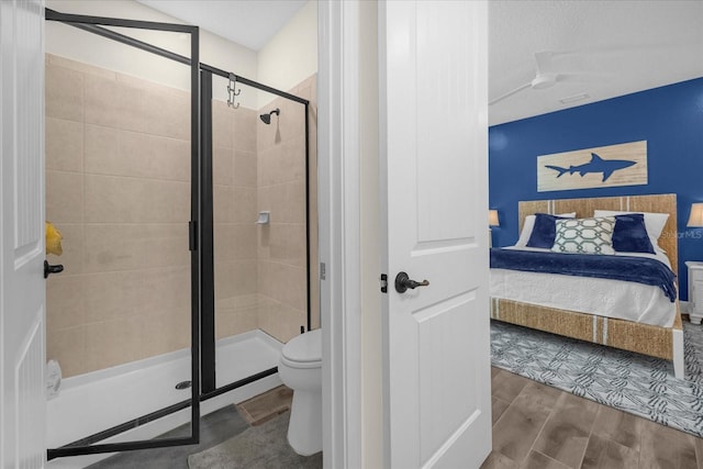 bathroom with a shower with door and toilet