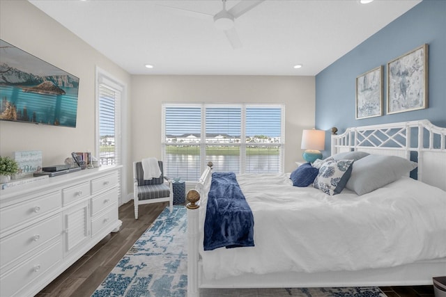 bedroom featuring ceiling fan and a water view