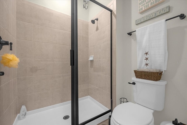 bathroom with toilet and a shower with shower door