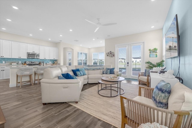 living room with ceiling fan, light hardwood / wood-style floors, and sink