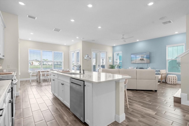 kitchen with ceiling fan, sink, a center island with sink, white cabinets, and appliances with stainless steel finishes