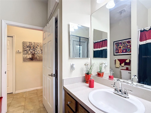 bathroom with vanity, tile patterned flooring, and toilet