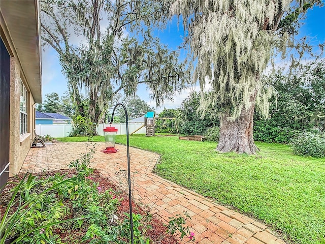 view of yard featuring a playground and a patio area