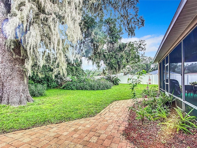 view of yard with a sunroom and a patio