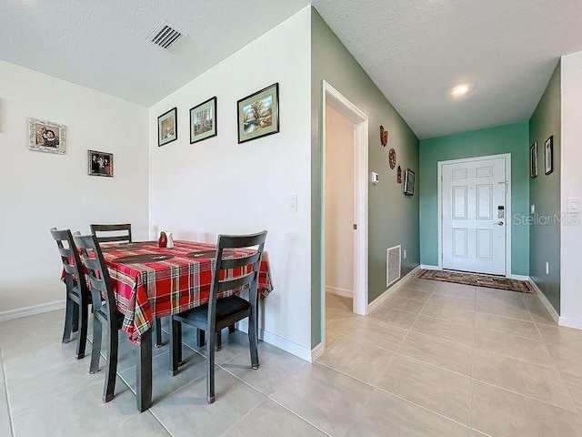 dining room featuring a textured ceiling and light tile patterned floors