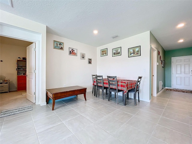 dining space featuring a textured ceiling and light tile patterned floors