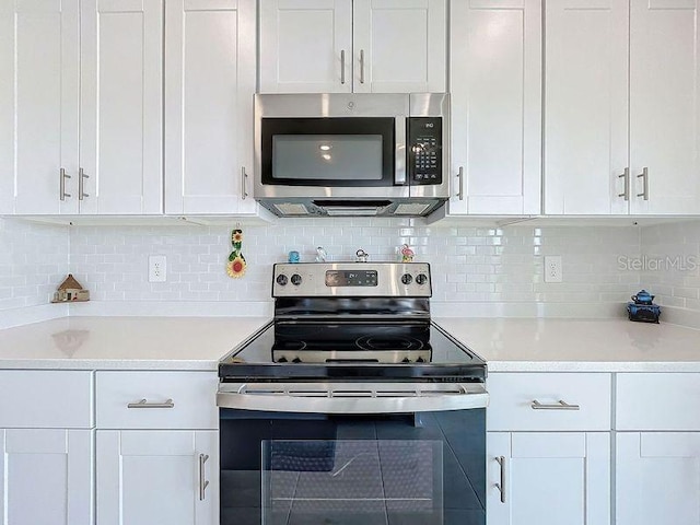 kitchen featuring tasteful backsplash, appliances with stainless steel finishes, and white cabinets