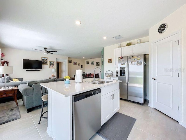 kitchen featuring a kitchen island with sink, a breakfast bar area, stainless steel appliances, sink, and white cabinetry