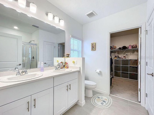 bathroom featuring vanity, toilet, tile patterned flooring, and an enclosed shower