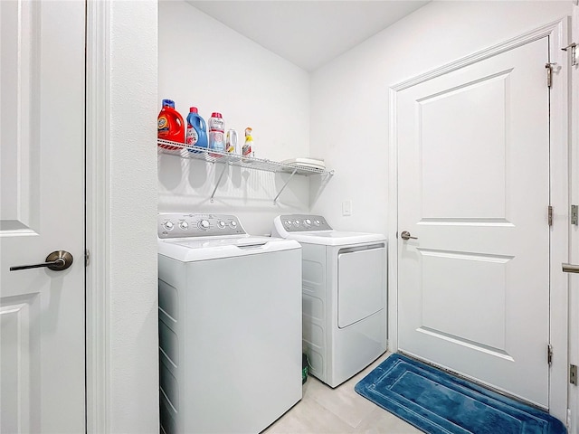 laundry room with washer and dryer and light tile patterned floors