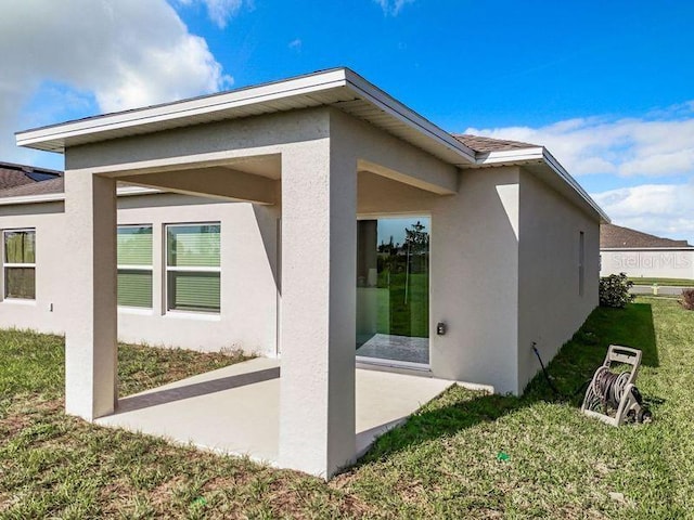 rear view of property featuring a patio area and a yard