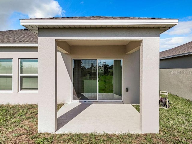 back of house with a patio and a lawn