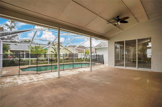 view of swimming pool featuring ceiling fan, glass enclosure, and a patio area