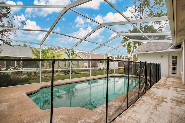 view of swimming pool featuring a patio and glass enclosure