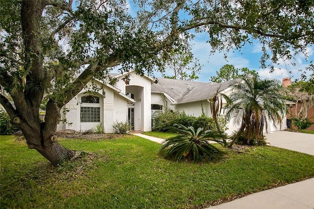 ranch-style house with a garage and a front lawn