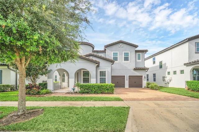 mediterranean / spanish-style house featuring a front lawn and a garage