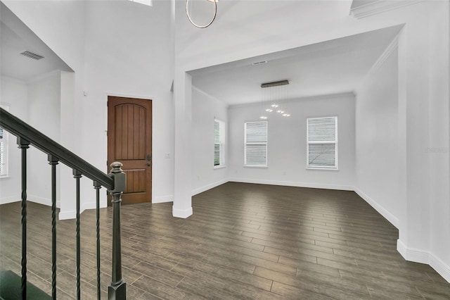 entrance foyer featuring ornamental molding, dark hardwood / wood-style flooring, and a chandelier