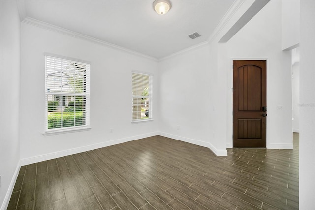 spare room featuring crown molding, dark wood-type flooring, and plenty of natural light