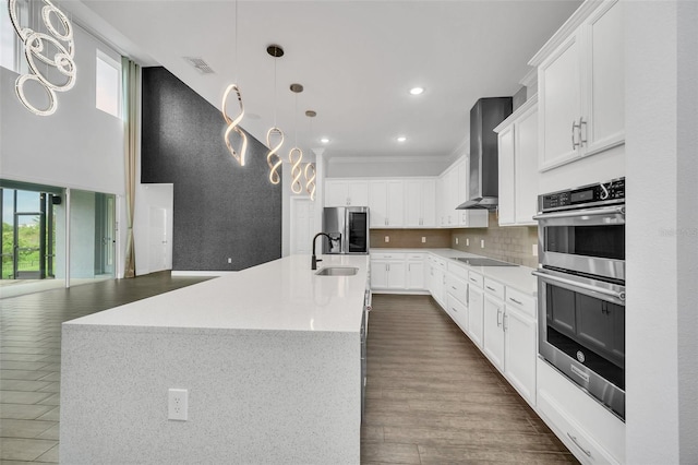 kitchen with an island with sink, a wealth of natural light, white cabinets, and appliances with stainless steel finishes