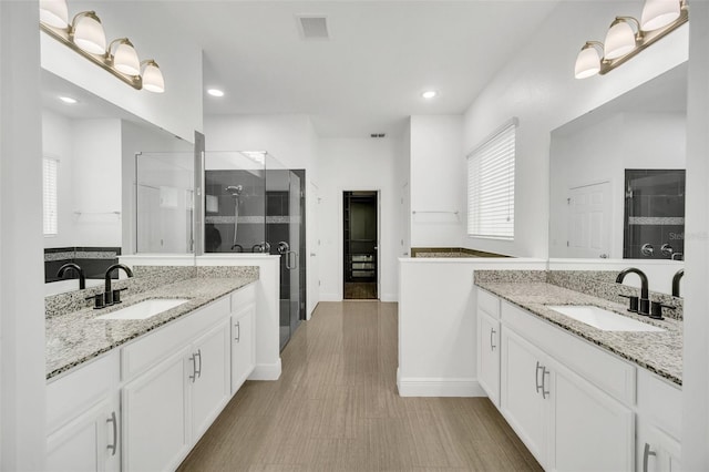 bathroom featuring walk in shower, vanity, and hardwood / wood-style floors