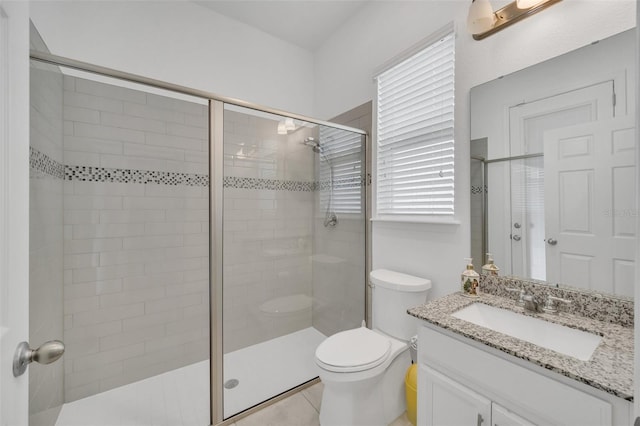 bathroom featuring walk in shower, vanity, tile patterned flooring, and toilet