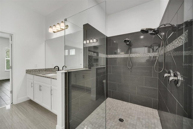 bathroom with vanity and a tile shower