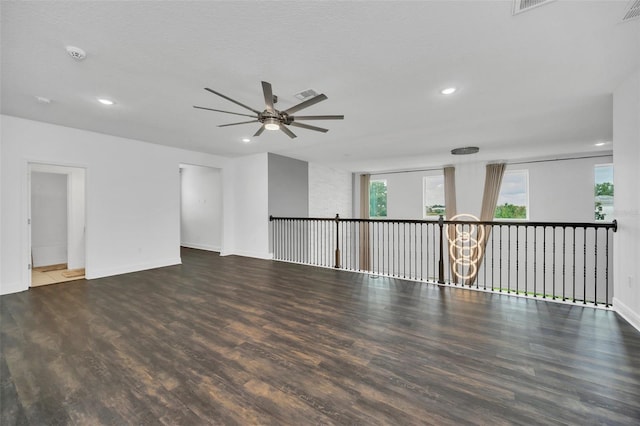 unfurnished room featuring a textured ceiling, ceiling fan with notable chandelier, and dark hardwood / wood-style floors