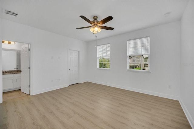 unfurnished bedroom featuring light wood-type flooring, connected bathroom, and ceiling fan