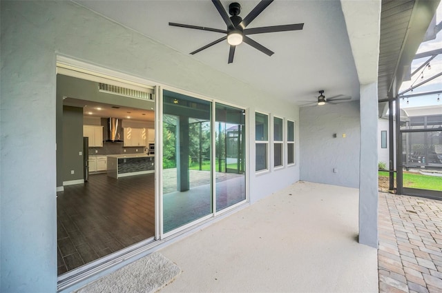 view of patio featuring glass enclosure and ceiling fan