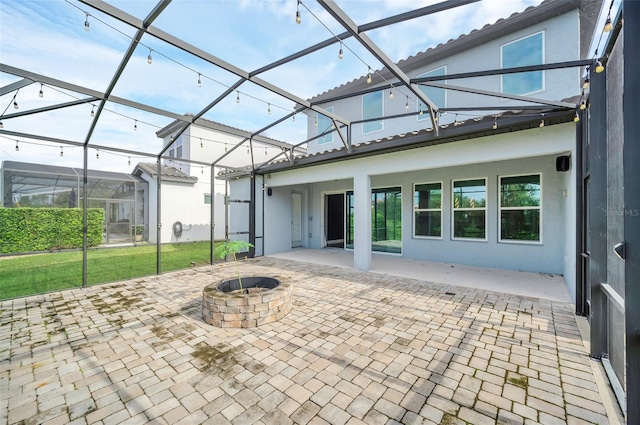 view of patio with glass enclosure and a fire pit