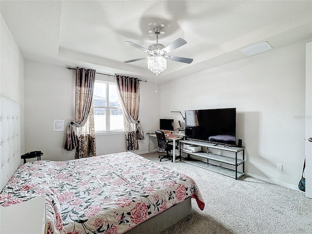 bedroom with ceiling fan, carpet floors, and a textured ceiling