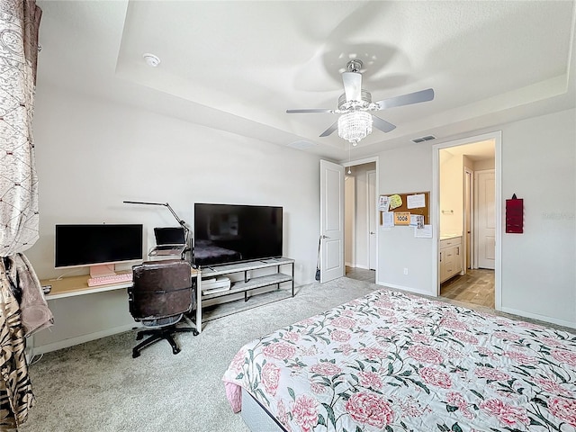 bedroom featuring a raised ceiling, ceiling fan, and light colored carpet