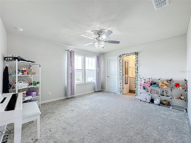 playroom with ceiling fan, light colored carpet, and a textured ceiling