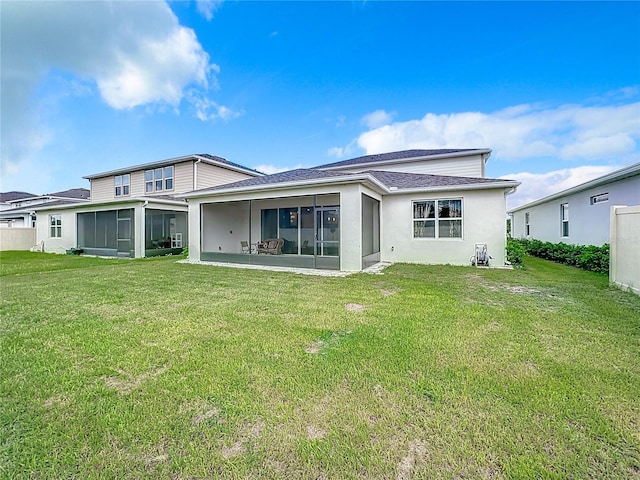 rear view of property with a sunroom and a yard