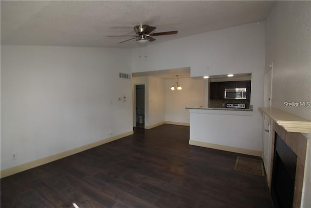 unfurnished living room featuring dark wood-type flooring and ceiling fan with notable chandelier