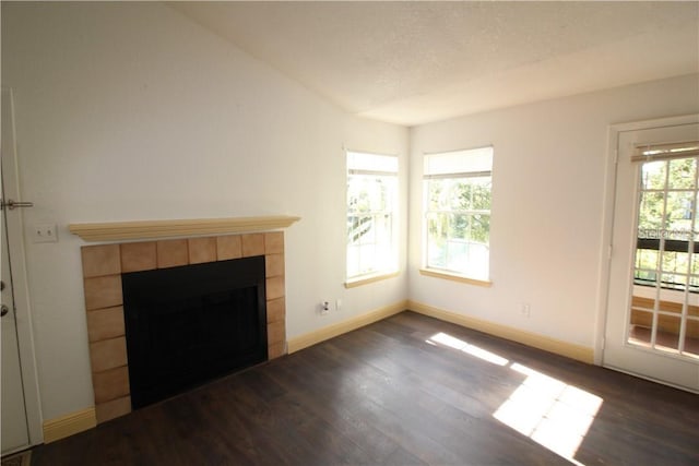 4400 Thornbriar Ln Unit A202, Orlando, FL 32822 - unfurnished living room with dark wood-style flooring, baseboards, a tiled fireplace, and a textured ceiling