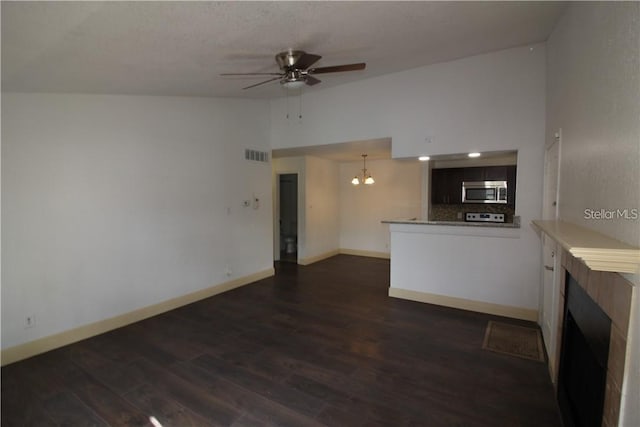 4400 Thornbriar Ln Unit A202, Orlando, FL 32822 - unfurnished living room featuring a tile fireplace, ceiling fan, baseboards, dark wood-style flooring, and high vaulted ceiling
