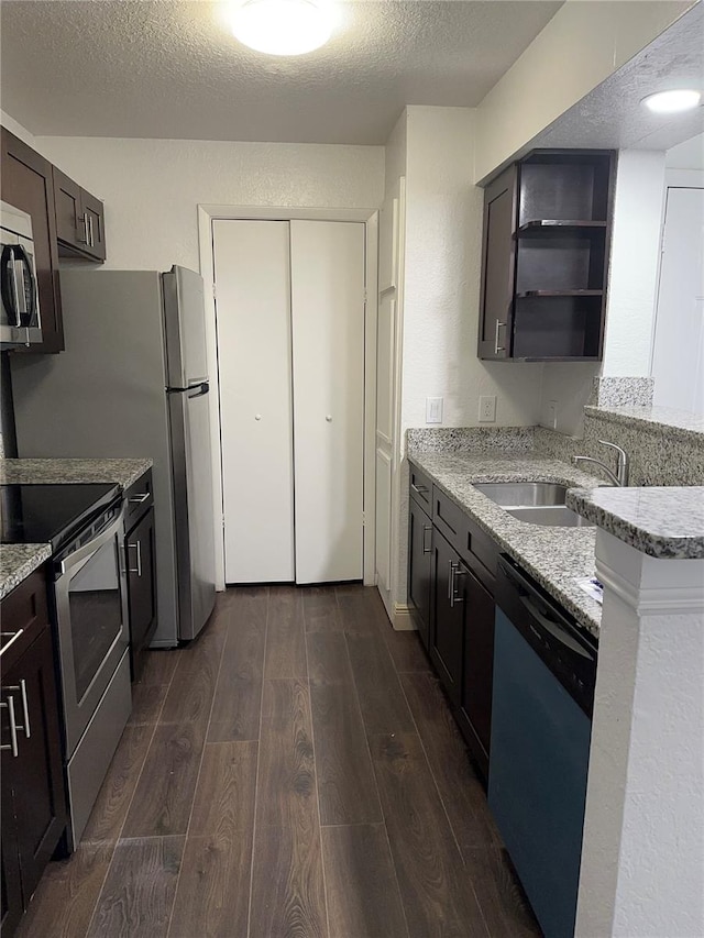 kitchen featuring a textured ceiling, dark brown cabinetry, stainless steel appliances, and dark hardwood / wood-style floors