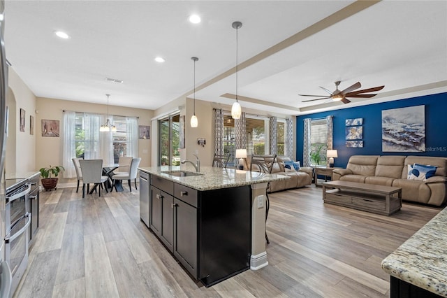 kitchen with light stone counters, decorative light fixtures, and a wealth of natural light