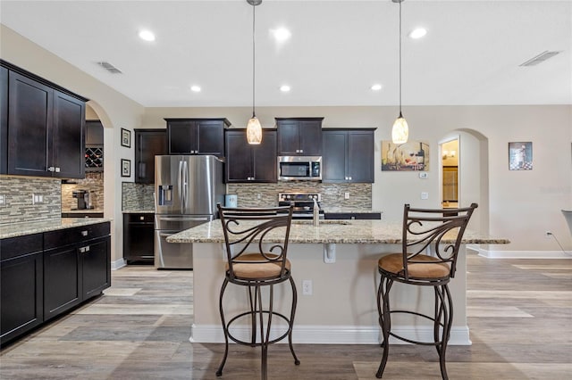 kitchen featuring appliances with stainless steel finishes, a center island with sink, sink, and pendant lighting