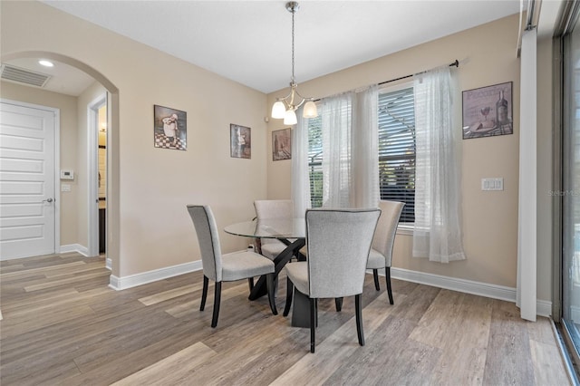 dining space featuring light wood-type flooring and a chandelier