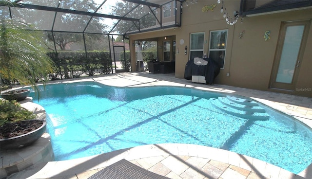 view of pool with a patio, a lanai, and pool water feature