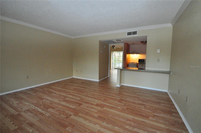 unfurnished living room with ornamental molding, a textured ceiling, and light hardwood / wood-style floors