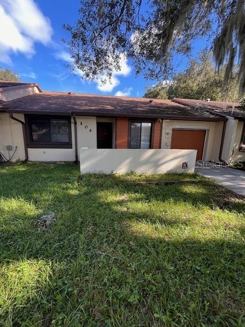 single story home with a front yard and a garage