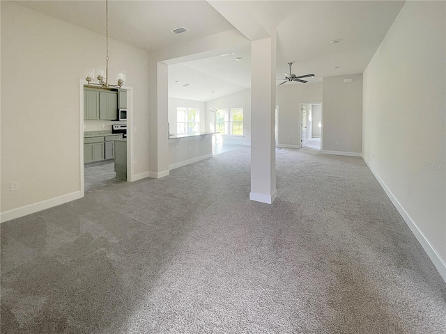 unfurnished living room with light carpet, vaulted ceiling, and ceiling fan with notable chandelier