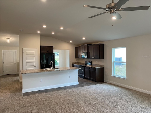 4306 Sagefield Dr, Harmony, FL 34773 - kitchen featuring black appliances, dark colored carpet, an island with sink, plenty of natural light, and vaulted ceiling