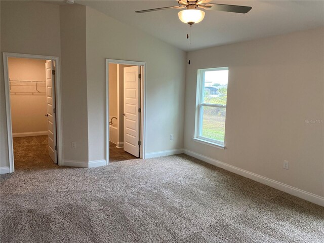 4306 Sagefield Dr, Harmony, FL 34773 - unfurnished bedroom featuring carpet floors, a walk in closet, baseboards, and lofted ceiling
